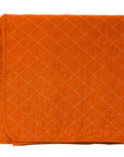 Orange quilted blanket on a white background