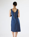 Woman wearing a blue polka dot dress on a white background