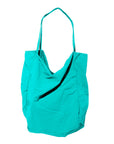 A blue canvas tote bag with a minimalist design and long handles.